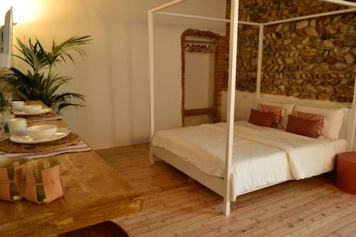 1 dormitorio con cama con dosel y mesa en La Locanda della Torre, en Marne di Filago