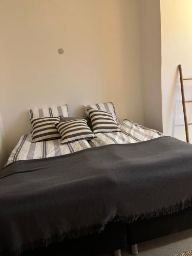 un letto con cuscini a righe in una camera da letto di Room 4 - Hawkraft kulturhotel a Vestervig
