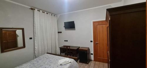 a bedroom with a bed and a table and a mirror at AFFITTACAMERE DOLCE SOGNO in Cherasco