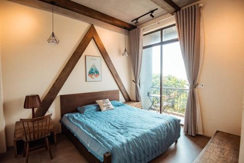 ein Schlafzimmer mit einem Bett und einem großen Fenster in der Unterkunft 1992 Tam Đảo - Venuestay in Tam Ðảo