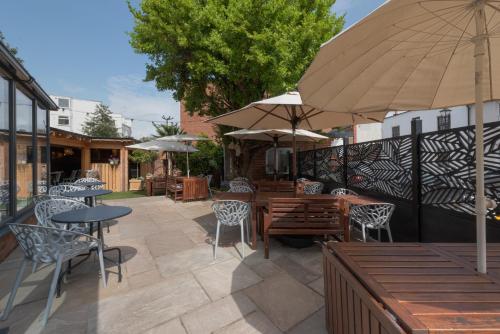 a patio with tables and chairs and an umbrella at Stattons Boutique Hotel & Restaurant in Portsmouth