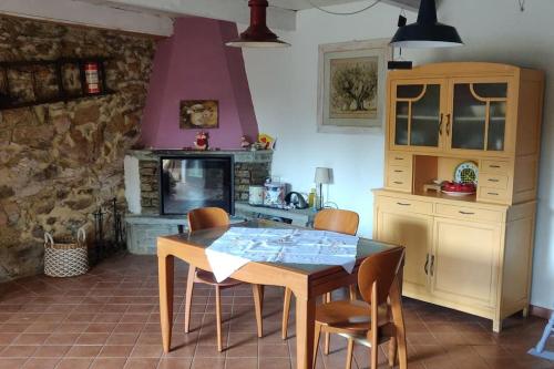 a kitchen with a table and chairs and a fireplace at Casa Camino in Rubiana