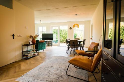 ein Wohnzimmer mit einem Sofa und einem Tisch in der Unterkunft Luxe Veluws Vakantiehuis met JACUZZI in Lunteren