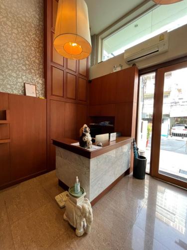 a lobby with a counter with two teddy bears sitting at it at Jhouse Thonglor in Khlong Toei