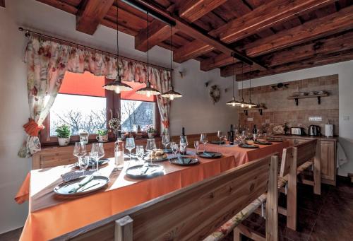 a dining room with a long table in a kitchen at VULCANO Guesthouse in Vinica