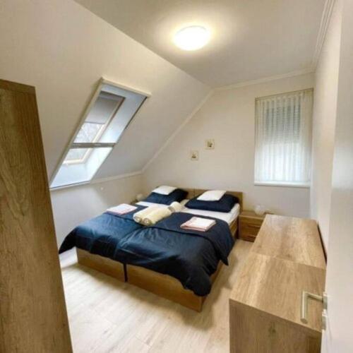 sypialnia z 2 łóżkami i oknem w obiekcie LILIBORI apartman w mieście Pápa