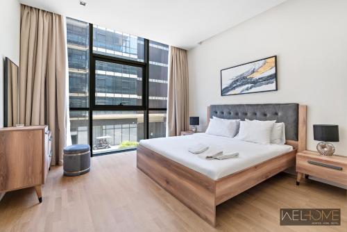 a bedroom with a bed and a large window at WelHome - Luxury Living in Dubai's City Walk Building 5 in Dubai