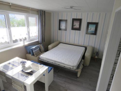 ザスニッツにあるFerienhaus in Sassnitz - klein aber fein bis 4 Personenのベッド、ソファ、テーブルが備わる客室です。