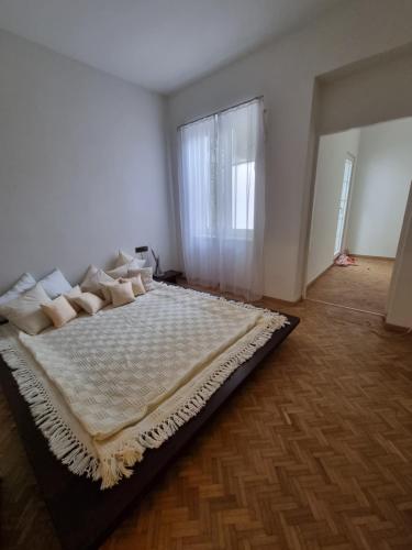 ein großes Bett in einem weißen Zimmer mit Fenster in der Unterkunft Altes Zollhaus in Höflein an der Donau