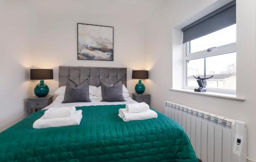 a bedroom with a green bed with two pillows at York Luxury Apartments, Bishopthorpe Rd in York