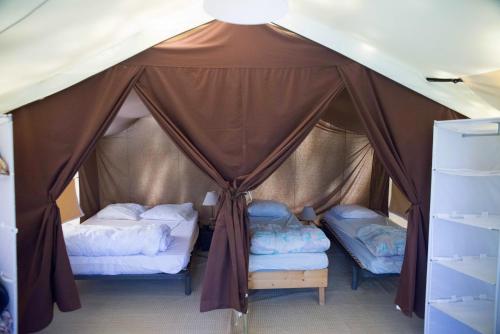 a bedroom with two beds in a tent at Camping la Grangeonne in Esparron-de-Verdon