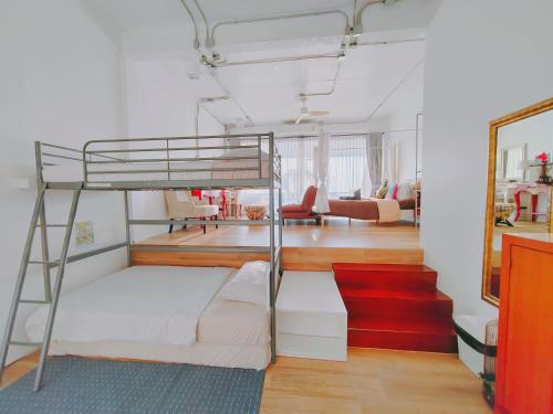 a bedroom with a bunk bed and a living room at มารินอส บีชเฮ้าส์ Marinos Beach house in Si Racha