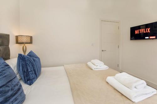 a white bedroom with two towels on a bed at York Luxury Apartments, Bishopthorpe Rd in York