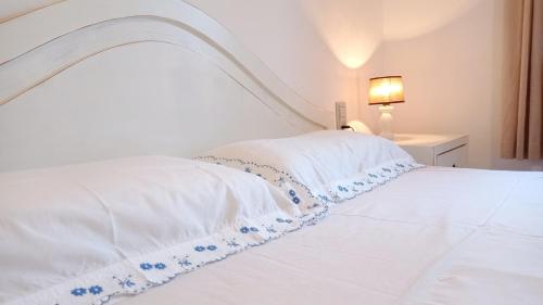 a bed with a white bedspread with blue flowers on it at Pregonda 13 Menorca in Son Parc