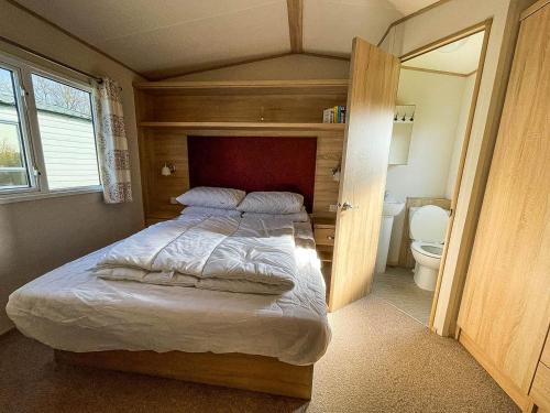 1 dormitorio con cama y aseo en 6 Berth Caravan At California Cliffs With Decking In Scratby Ref 50015kc, en Great Yarmouth