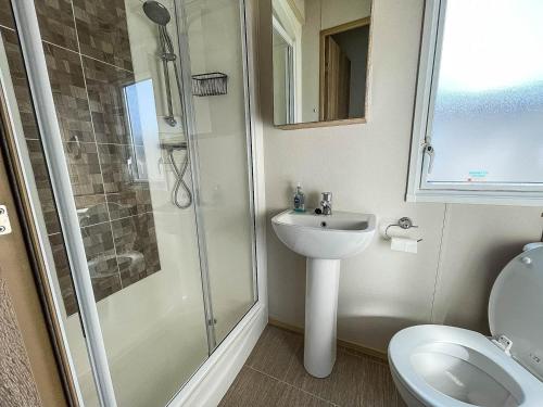 a bathroom with a shower and a toilet and a sink at 6 Berth Caravan At California Cliffs With Decking In Scratby Ref 50015kc in Great Yarmouth