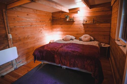 um quarto com paredes de madeira e uma cama com 2 almofadas em Luxe vakantiehuis in het bos met jacuzzi en sauna em Lunteren