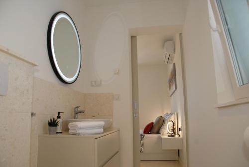 een badkamer met een wastafel en een spiegel aan de muur bij Villa Nonna in Vodice