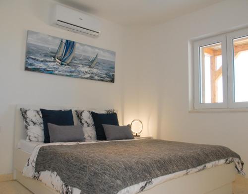 een witte slaapkamer met een bed en een raam bij Villa Nonna in Vodice