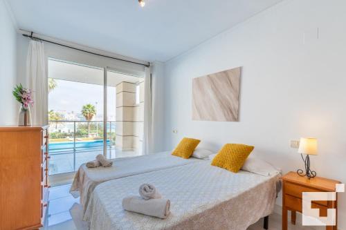 a bedroom with a bed and a large window at Apartamento Mesana 13 - Grupo Turis in Calpe