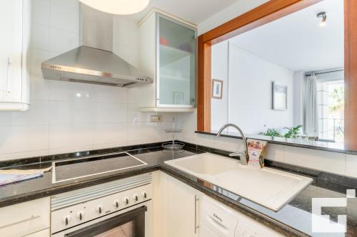 cocina blanca con fregadero y ventana en Apartamento Mesana 13 - Grupo Turis, en Calpe