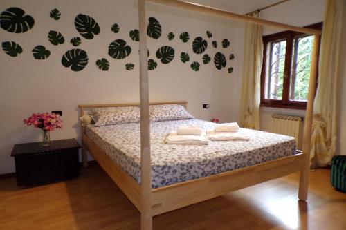 a bedroom with a bed with green leaves on the wall at Villetta Mazzini Front Lake - Happy Rentals in Peschiera del Garda