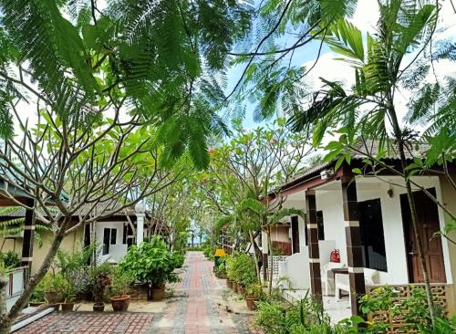 a street in a village with houses and trees at Langkapuri Resort Langkawi in Pantai Cenang