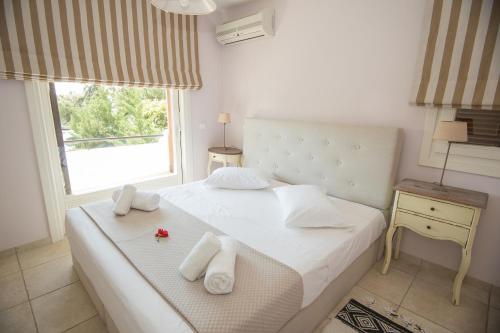 a bedroom with a bed with towels on it at Grand Bleu Porto Heli - Beachfront House, Agios Emilianos in Porto Heli
