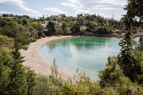 einen Strand inmitten eines Wasserkörpers in der Unterkunft Grand Bleu Porto Heli - Beachfront House, Agios Emilianos in Porto Heli