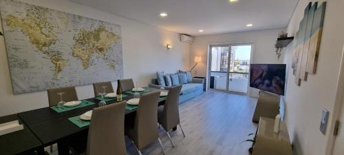 a dining room with a table and a map on the wall at Pé n'Areia Guesthouse in Vila do Conde