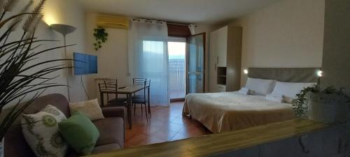 ein Schlafzimmer mit einem Bett, einem Sofa und einem Tisch in der Unterkunft Alloggio turistico a Via Modugno in Vitinia