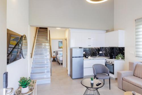 ein Wohnzimmer und eine Küche mit einer Treppe in einem Haus in der Unterkunft Bianco Mare Studios-Apartments in Kalivia Poligirou