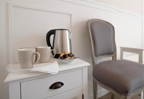 a table with two coffee cups and a chair at Villa Luce Assisi Rooms & Suites in Assisi