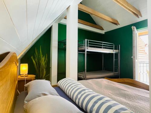 a bedroom with green walls and a bunk bed at Mikalo House in Vilnius