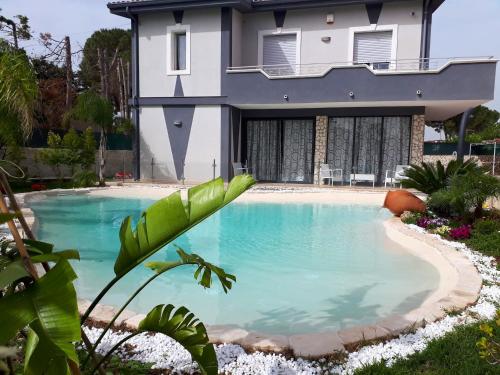 a swimming pool in front of a house at Charming Villa in Fontane Bianche with Private Pool in Fontane Bianche