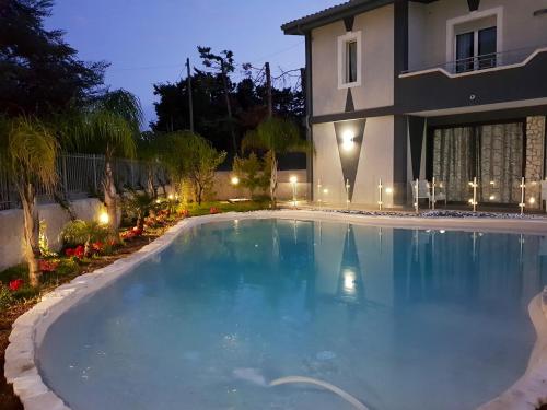 a swimming pool in front of a house at night at Charming Villa in Fontane Bianche with Private Pool in Fontane Bianche