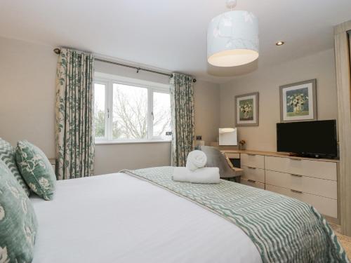 1 dormitorio con 1 cama grande y TV en Holme Fell, en Coniston