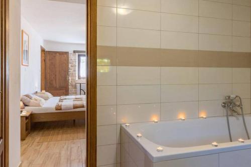 a bathroom with a tub and a bedroom with a bed at Villa Histria - Adriatic Luxury Villas in Manjadvorci