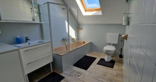 een badkamer met een bad, een toilet en een wastafel bij CinemApartman Eger in Eger