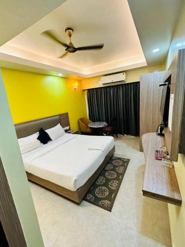 a bedroom with a bed and a television in it at Royal Beach International in Puri
