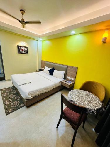 a bedroom with a bed and a table and a chair at Royal Beach International in Puri