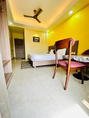 a bedroom with a bed and a table and a chair at Royal Beach International in Puri