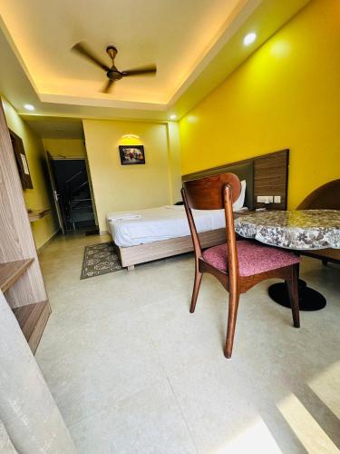 a bedroom with a bed and a table and a chair at Royal Beach International in Puri
