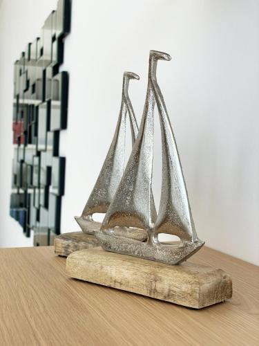 two metal ships sitting on a wooden table at Gli Scogli Luxury Residence Hotel in Chiavari
