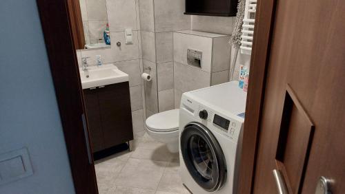 ein Badezimmer mit einem WC und einer Waschmaschine in der Unterkunft Nocleg u Kasi TRÓJMIASTO in Kowale
