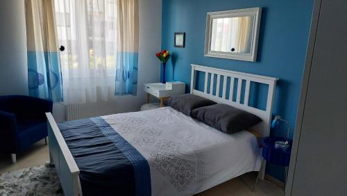 Dormitorio azul con cama y pared azul en Nocleg u Kasi TRÓJMIASTO en Kowale