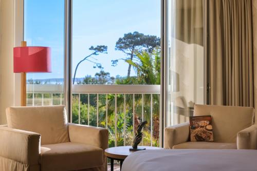 Zimmer mit 2 Stühlen und einem großen Fenster in der Unterkunft Hotel Onda in Calvi