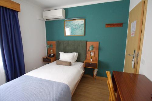 a hotel room with a bed and a desk and a table at WOT Ericeira in Ericeira