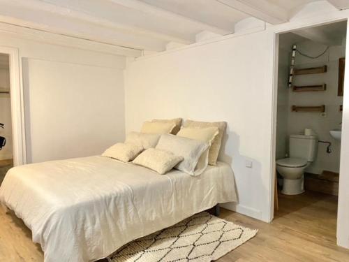 a white bedroom with a bed and a toilet at New design apartment in Barcelona center. in Barcelona