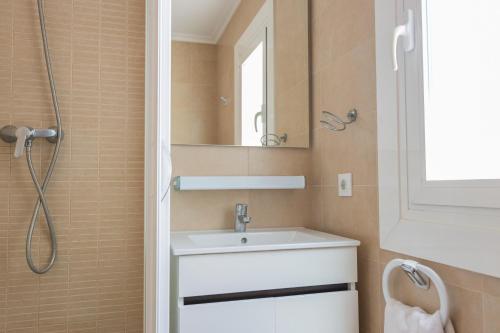 a bathroom with a sink and a mirror at Villas 84 Est & Oest, Son Bou By MENORCARENTALS in Son Bou